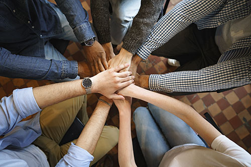 Picture from above of a circled group of people making a hand stack